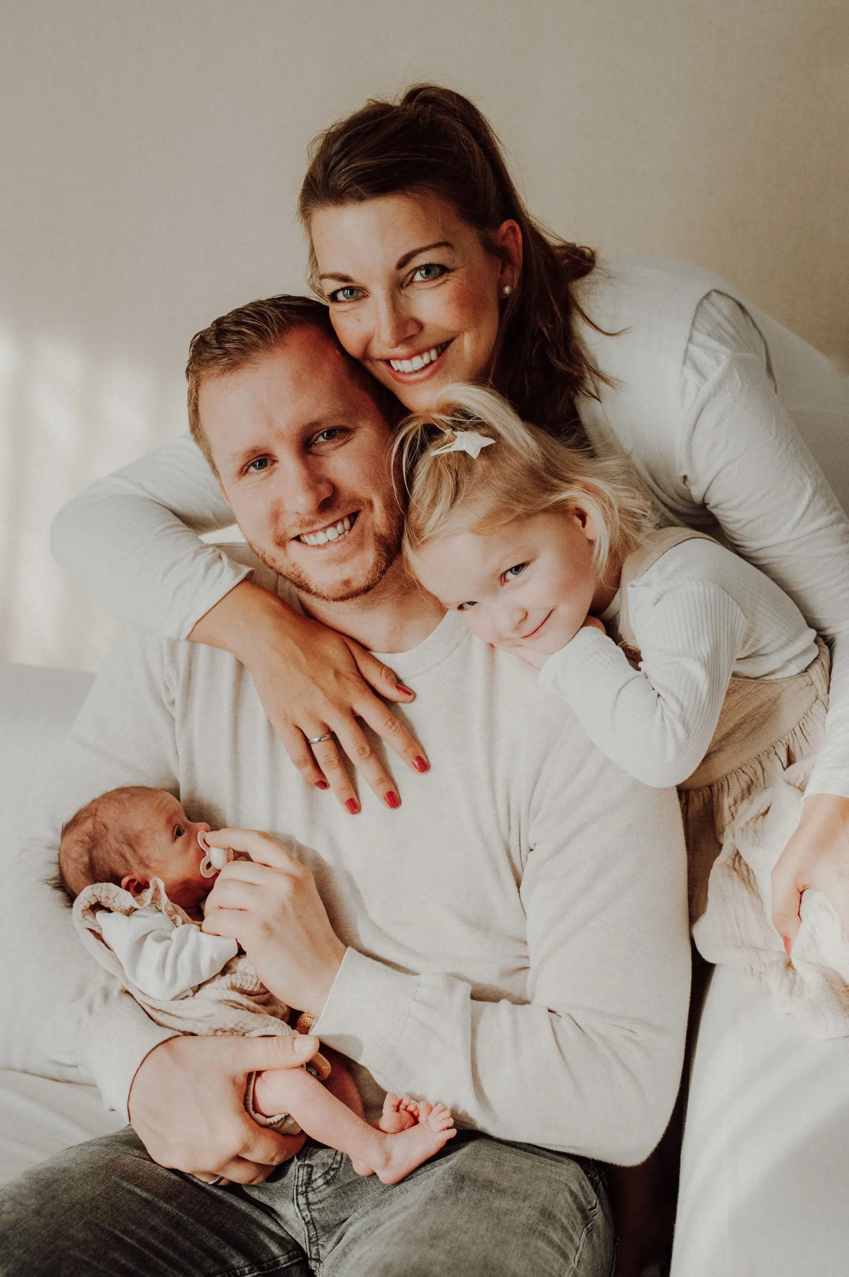 Glücklich lächelnde Familie mit Kleinkind und Baby im Studio fotografiert von Valerija Ecker